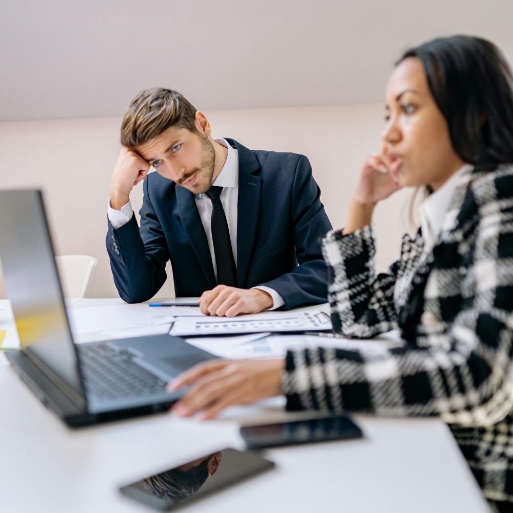 Business consultants discussing strategy and reviewing documents during a professional meeting at an office workspace.