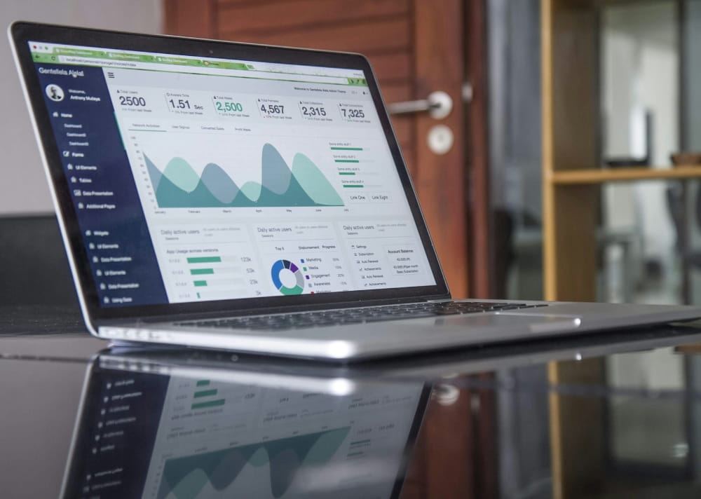 Laptop displaying a digital marketing analytics dashboard with charts and performance metrics, representing online campaign tracking and business insights.
